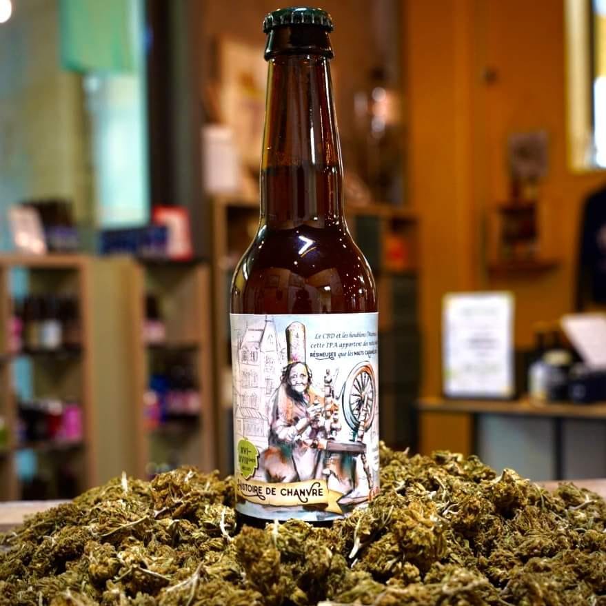 Bouteille de bière au CBD posée sur un lit de fleurs de chanvre